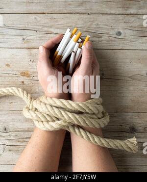 hand tied tobacco male hands are holding cigarettes, concept addiction, smoking, cigarette addiction, photo taken from above Stock Photo cut Italian method Tie - Tobacco w/ Brown