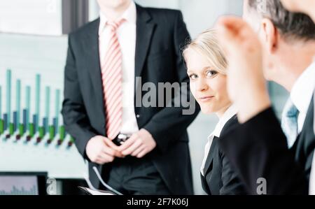 Business - presentation for the team, female, colleague is standing on the flipchart in office Stock Photo