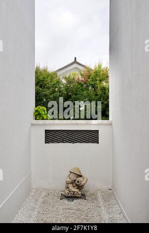 White walls and a ornamentation on ground with white sands, tree and house far away. Stock Photo