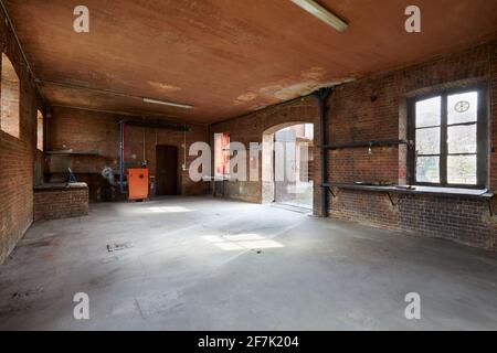 Old, empty workshop interior with brick walls in a sunny morning Stock Photo