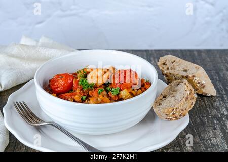 Chorizo, lentil and prawn stew with roasted tomatoes Stock Photo