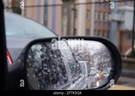 View from rear-view mirror in a rainy day with water drops Stock Photo