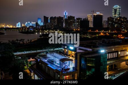 Haikou cityscape with rooftop terrace and view on the coastal city bay and skyline illuminated at night in Haikou Hainan China Stock Photo