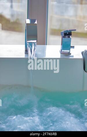 Modern faucet on the hot tub Stock Photo