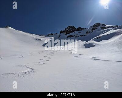 Man skier rides through powder snow to the mountains. Winter sports freeride. Etscherzapfen in Glarus Swiss, Skimo Stock Photo