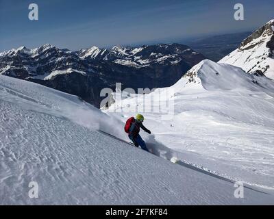 Man skier rides through powder snow to the mountains. Winter sports freeride. Etscherzapfen in Glarus Swiss, Skimo Stock Photo