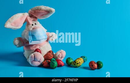 masked white hare and easter eggs lie Stock Photo