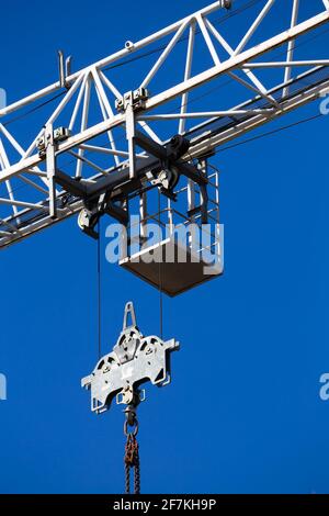 Details of the construction crane against the background of blue sky. Crane chain and pulley system. Photo taken on a sunny day. Stock Photo