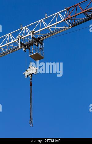 Details of the construction crane against the background of blue sky. Crane chain and pulley system. Photo taken on a sunny day. Stock Photo