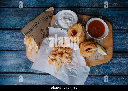 Snacks to beer on a wooden tray on a blue background. Stock Photo