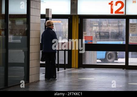 A woman in a perspex face mask waiting for a bus at Preston Bus Station, Lancashire, UK. Stock Photo