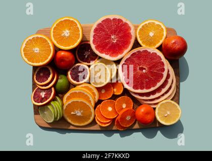 Set of different sliced citrus fruits on wooden board. Orange, grapefruit, lime, tangerine, lemon. Organic SPA cosmetics with orange oil and vitamin C Stock Photo