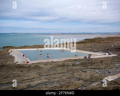 People enjoying the Rock Pool outdoor tidal swimming pool at the seaside village of Westward Ho!, North Devon, England. Stock Photo