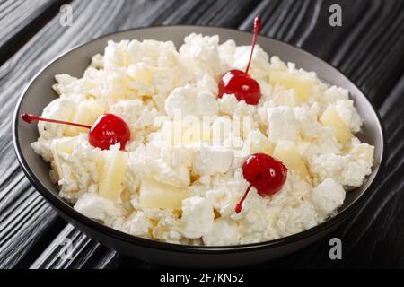 American Glorified Rice Salad topped with maraschino cherries close-up in a plate on the table. Horizontal Stock Photo