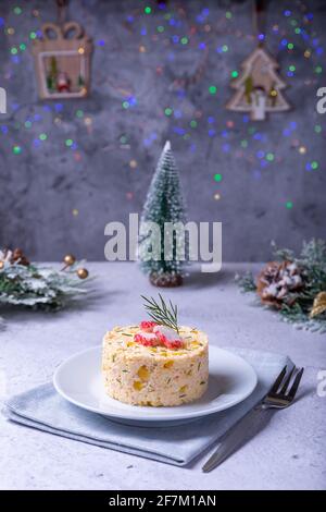 Crab salad with corn and eggs on a white plate. New Year's and Christmas. Traditional Russian salad. Close-up. Stock Photo