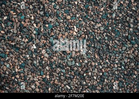 Gravel texture. Small stones, little rocks, pebbles in many shades of grey, white, brown, yellow colour. Background of small stones in oval shape. Tex Stock Photo