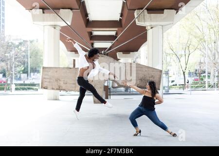 Caucasian woman and African American man dancing having fun in the city center. Space for text. Stock Photo
