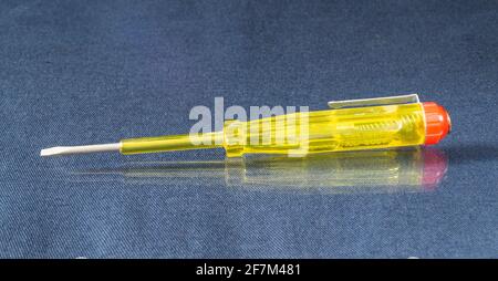 Electric indicator to check the voltage.Yellow instrument on the table with reflection Stock Photo