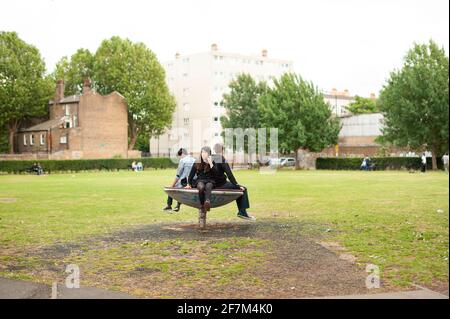 English teenagers hanging out around Brick Lane. A tight-knit circle of friends concept. Allen Gardens, East London, UK. Jul 2015 Stock Photo