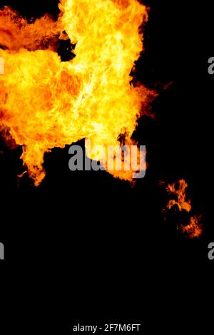 Dangerous orange yellow flashing fire flames on black background. Burning hot flame with energy in motion. Industry power and heat from pellet oil gas Stock Photo