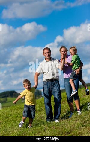 Happy family (father, mother and two sons) having a walk on a beautiful summer day Stock Photo