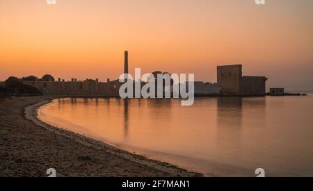 Dawn light on the ruins of the old factory for the processing of tuna and of the medieval watch tower at Vendicari, Syracuse, Sicily, Italy. Stock Photo