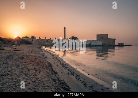 Dawn light on the ruins of the old factory for the processing of tuna and of the medieval watch tower at Vendicari, Syracuse, Sicily, Italy. Stock Photo