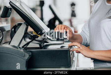 Close up of saleswoman hands accounting, billing some goods for sale, finance concept, getting a sale by stamp Stock Photo