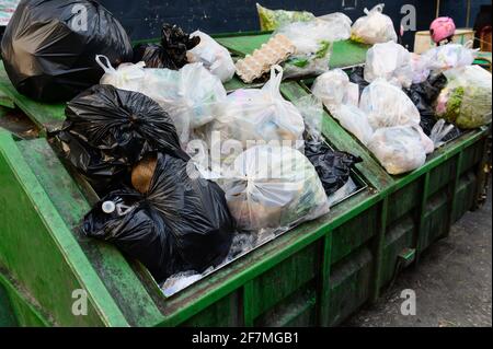 Green dumpsters being full with garbage Stock Photo