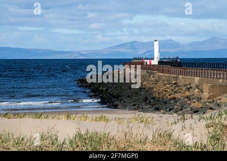 View of Isle of Arran Scotland from Ayr beach with jetty and harbour light Stock Photo