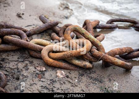 Rusty chain on beach Stock Photo