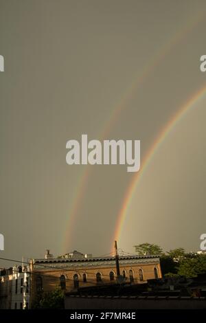 A double rainbow over apartment buildings in Brooklyn on a gloomy day Stock Photo