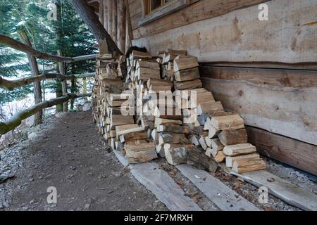 Pile of small logs in front of a cottage. Stock Photo