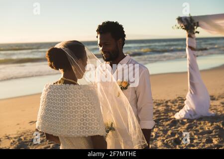 African american couple in love getting married on beach looking to each other Stock Photo