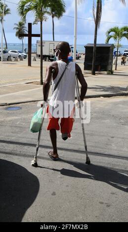 salvador, bahia, brazil - february 4, 2021: man with amputated leg using crutches in the Itapua neighborhood in the city of Salvador. *** Local Captio Stock Photo