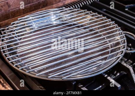 Angle view of a broiler pan, clean and washed and ready for roasting. Sitting on top of a modern stove top, marble backsplash in the back. Stock Photo