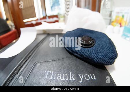 Slow pan up from a card saying thank you and a mask showing small business thanking consumers keeping them safe during the coronavirus pandemic by Stock Photo