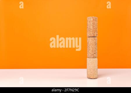 Wine corks on white table against bright orange background. Minimalistic, vivid colors. Stock Photo