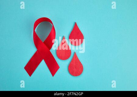 Awareness oncept with blood drop and red ribbon. World Hamophilia day or blood donor day. Stock Photo