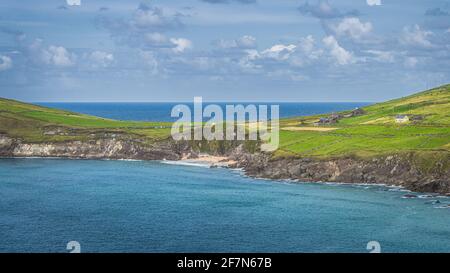 Tourist swimming in the see and relaxing on small hidden Coumeenoole Beach between cliffs in Dingle Peninsula, Wild Atlantic Way, Kerry, Ireland Stock Photo