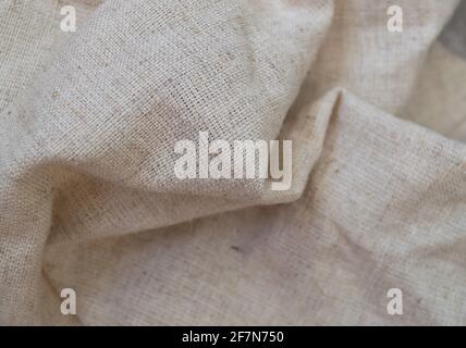 Rough linen fabric is randomly folded. Textile background Stock Photo