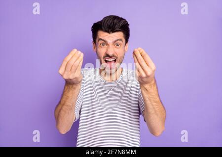 Photo of angry aggressive guy hold fingers open mouth yell wear striped t-shirt isolated purple background Stock Photo