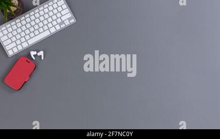 Basic wireless mobile work desktop with smartphone, computer keyboard and baby plant Stock Photo