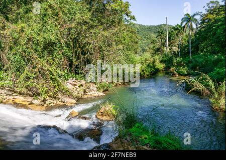 The rushing water of the El Nicho lower falls form a pristine natural swimming pool in El Nicho Nature Park, Cienfuegos province, Cuba. Stock Photo