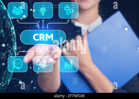 Business, Technology, Internet and network concept. Young businessman working on a virtual screen of the future and sees the inscription: CRM Stock Photo