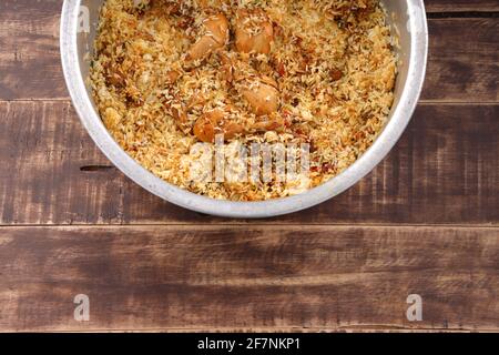 Dum chicken biriyani, close up image of Kerala-Thalassery biriyani  which is mixed with masala and yellow in colour arranged in a big aluminium cookin Stock Photo