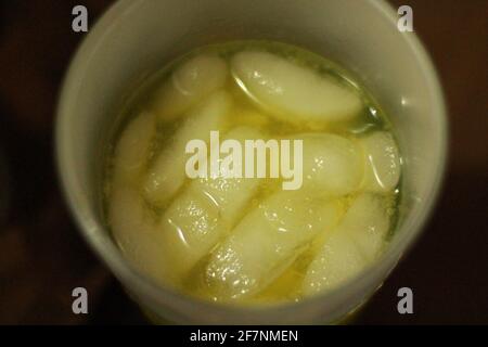 Top view of ice floating in orange juice Stock Photo