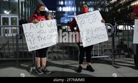 Los Angeles, CA, USA. 8th Apr, 2021. Two protesters hold signs during a 'Housing not Cops' protest in front of the Los Angeles Police Headquarters on Thursday night. They came together to speak out against residential evictions and against the police department's budget. Credit: Young G. Kim/Alamy Live News Stock Photo