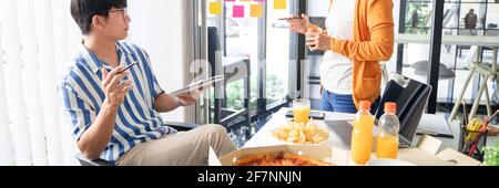 Business team workers discussing work and prepare pizza and potato chips to sharing meal at lunch break for good relations in office Stock Photo