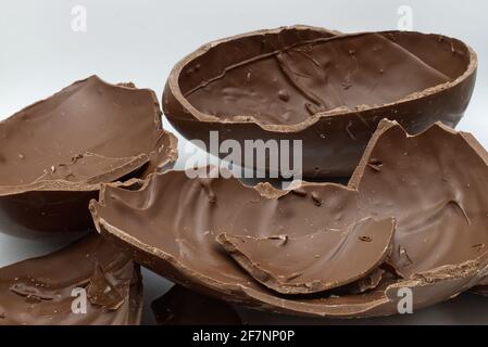 Broken chocolate Easter egg in a bowl isolated on white background Stock Photo